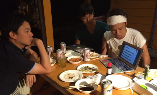 机を囲む男性達